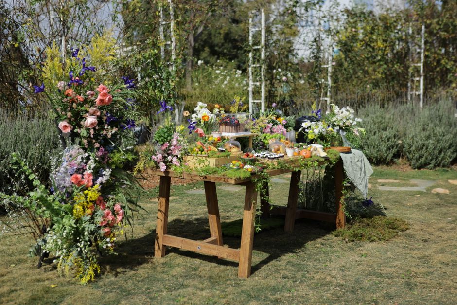 Tuin versierd met pompoenen en maïs voor herfst.
